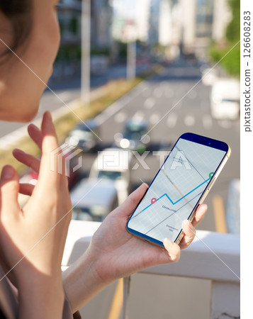 一位女士正在查看地圖應用程式以尋找目的地 一位女士正在查看地圖應用程式以尋找目的地 126608283