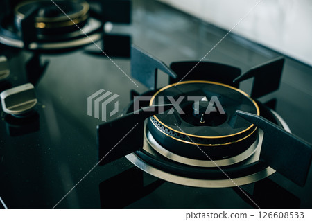 Luxurious black and gold stove top an opulent choice for high-end kitchens. Modern design clean appliance lavish addition to upscale house interiors give me. Luxurious black and gold stove top an opulent choice for high-end kitchens. Modern design clean appliance lavish addition to upscale house interiors give me. 126608533