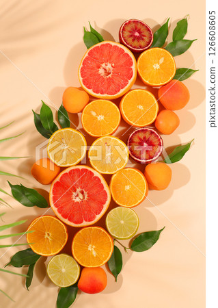 Fruity sunny banner. Summer in a snapshot, oranges, apricots, lemons, grapefruit on a bright background with shadows from a palm tree, Tropical background with exotic fruits, template for your design. Fruity sunny banner. Summer in a snapshot, oranges, apricots, lemons, grapefruit on a bright background with shadows from a palm tree, Tropical background with exotic fruits, template for your design. 126608605