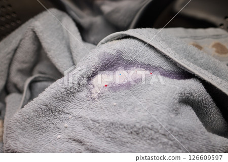 Soiled Gray Towel with Various Stains and Marks Found in the Laundry Basket and Pile 126609597