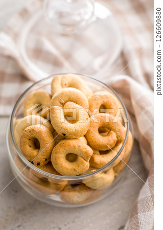 Salted crispy snack rings in jar on kitchen table. Salted crispy snack rings in jar on kitchen table. 126609880