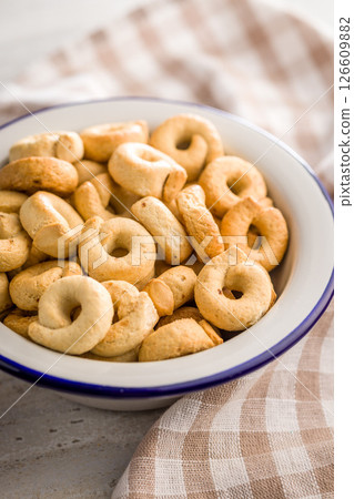 Salted crispy snack rings in bowl on kitchen table. 126609882