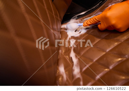 Cleaning a Luxury Car Seat with a Detail Brush and Foam for Maintaining Its Appearance Cleaning a Luxury Car Seat with a Detail Brush and Foam for Maintaining Its Appearance 126610522