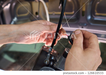 Automotive Repair Skilled Hands Working on Car Wiring for Efficient Performance and Safety Automotive Repair Skilled Hands Working on Car Wiring for Efficient Performance and Safety 126610533