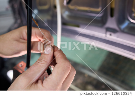 Automotive Repair Skilled Hands Working on Car Wiring for Efficient Performance and Safety Automotive Repair Skilled Hands Working on Car Wiring for Efficient Performance and Safety 126610534