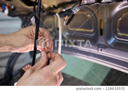 Automotive Repair Skilled Hands Working on Car Wiring for Efficient Performance and Safety Automotive Repair Skilled Hands Working on Car Wiring for Efficient Performance and Safety 126610535