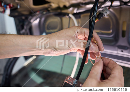 Automotive Repair Skilled Hands Working on Car Wiring for Efficient Performance and Safety Automotive Repair Skilled Hands Working on Car Wiring for Efficient Performance and Safety 126610536