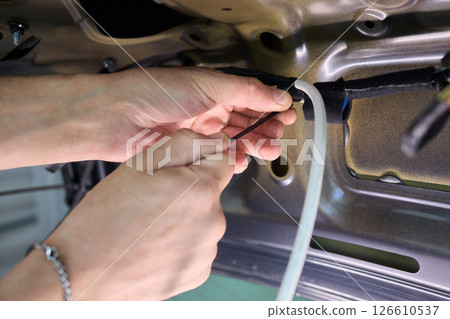 Automotive Repair Skilled Hands Working on Car Wiring for Efficient Performance and Safety Automotive Repair Skilled Hands Working on Car Wiring for Efficient Performance and Safety 126610537