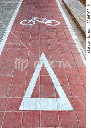 Spain, Valencia, March 29, 2024: Bicycle Lane Marking With a Red Pathway and Warning Symbol for Cyclists in an Urban Area 126610946