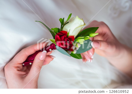 Bride With a Lovely Red and White Boutonniere During Spring Wedding Prep. 126610952