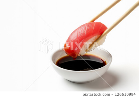 Fresh tuna nigiri sushi being dipped into soy sauce with chopsticks Fresh tuna nigiri sushi being dipped into soy sauce with chopsticks 126610994