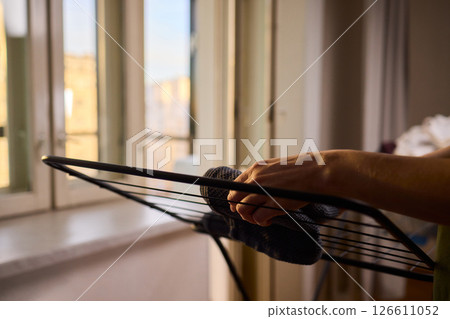 Arranging Freshly Laundered Towels Neatly on a Drying Rack for Optimal Drying and Organization 126611052