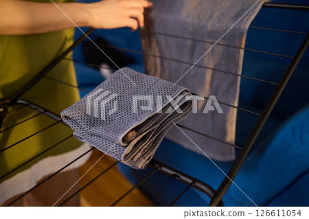 Arranging Freshly Laundered Towels Neatly on a Drying Rack for Optimal Drying and Organization 126611054
