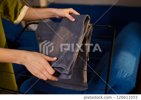 Arranging Freshly Laundered Towels Neatly on a Drying Rack for Optimal Drying and Organization 126611055