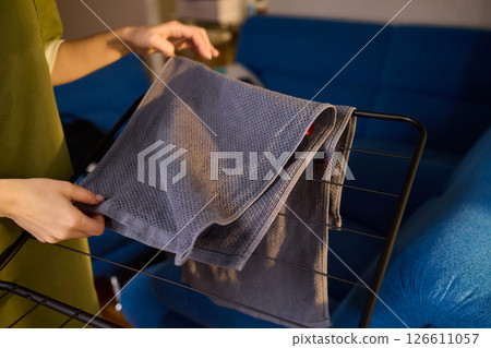 Arranging Freshly Laundered Towels Neatly on a Drying Rack for Optimal Drying and Organization 126611057