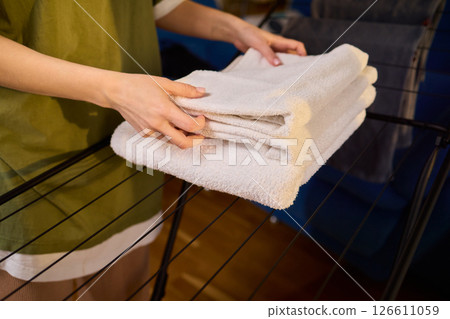 Arranging Freshly Laundered Towels Neatly on a Drying Rack for Optimal Drying and Organization 126611059