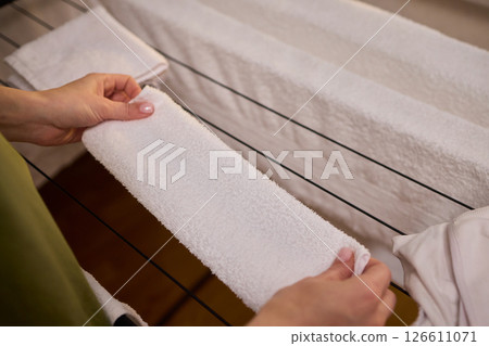 Arranging Freshly Laundered Towels Neatly on a Drying Rack for Optimal Drying and Organization Arranging Freshly Laundered Towels Neatly on a Drying Rack for Optimal Drying and Organization 126611071