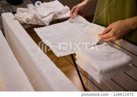 Arranging Freshly Laundered Towels Neatly on a Drying Rack for Optimal Drying and Organization 126611072