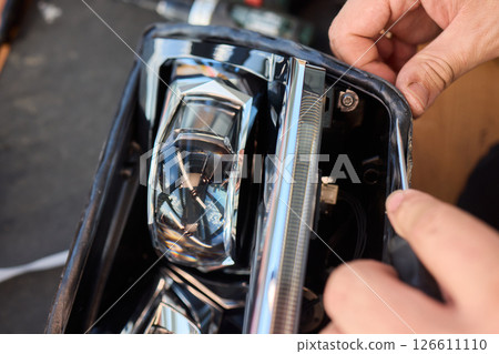 Careful precision is essential when installing a car headlight assembly for optimal performance 126611110