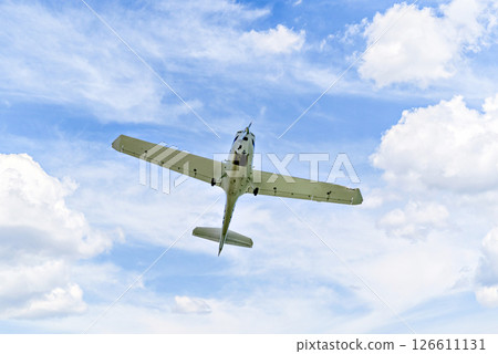 Single engine ultralight plane flying in the blue sky with white clouds Single engine ultralight plane flying in the blue sky with white clouds 126611131