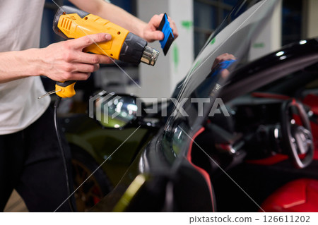 The Professional Windshield Tinting Process Conducted in a Modern Auto Showroom Environment 126611202