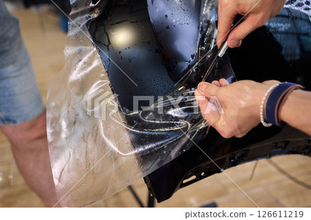 Applying a Protective Film on the Surface of Your Car for Enhanced Durability and Shine Applying a Protective Film on the Surface of Your Car for Enhanced Durability and Shine 126611219