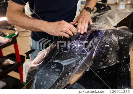 Applying a Protective Film on the Surface of Your Car for Enhanced Durability and Shine 126611225