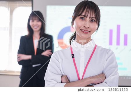 會議室裡,一男一女雙手交叉站在螢幕前 會議室裡,一男一女雙手交叉站在螢幕前 126611553