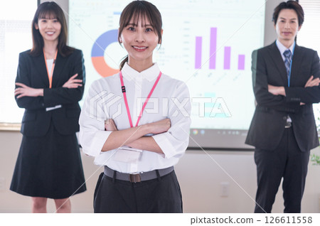 會議室裡,一男一女雙手交叉站在螢幕前 會議室裡,一男一女雙手交叉站在螢幕前 126611558