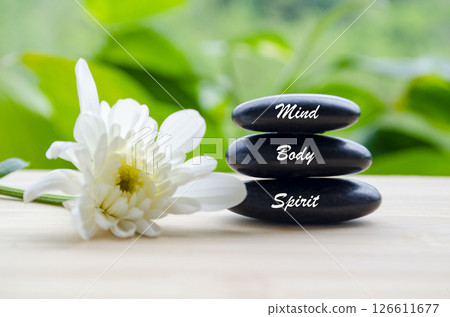 Mind, Body and Spirit text on zen stones with white color flower and blur background Mind, Body and Spirit text on zen stones with white color flower and blur background 126611677