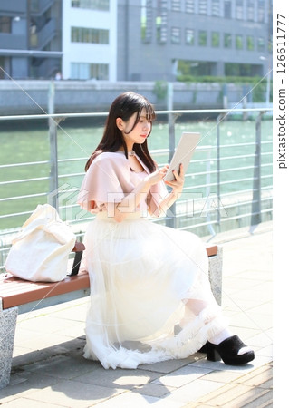 一個操作平板電腦的女人 126611777