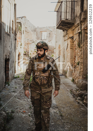 Soldier Looks For Something Among The Ruins Of The Destroyed City Soldier Looks For Something Among The Ruins Of The Destroyed City 126612239
