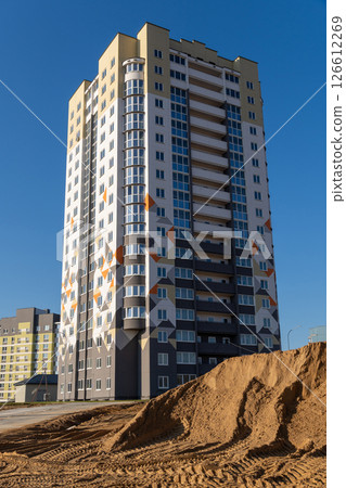 Construction of a multi-storey building with a crane against the blue sky. Construction of a multi-storey building with a crane against the blue sky. 126612269