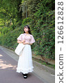 Woman walking on the pavement 126612828