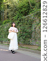 Woman walking on the pavement 126612829
