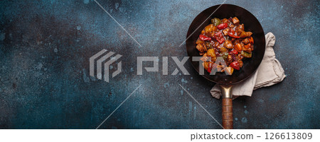 Sweet and sour pork in wok pan with peppers and pineapple top view, traditional Chinese dish 126613809
