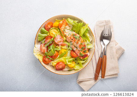 Grilled salmon fillet with fresh vegetables tomatoes salad on a plate top view, dieting and healthy food 126613824