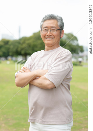 公園裡，一位老人交叉雙臂大笑 126613842