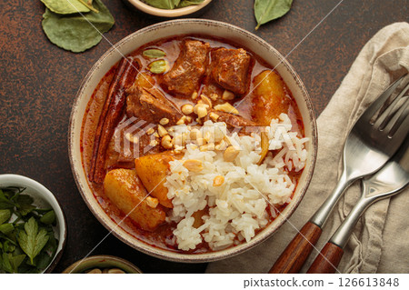 Delicious massaman curry with beef, potatoes, rice, and peanuts is served in bowl top view, Thai cuisine 126613848