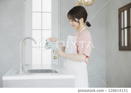 A woman doing housework in the kitchen 126614151