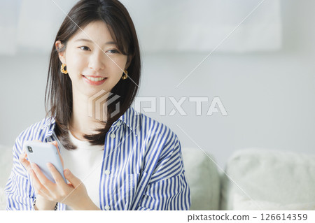 A woman watching a smartphone A woman watching a smartphone 126614359