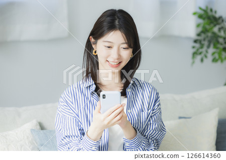 A woman watching a smartphone 126614360