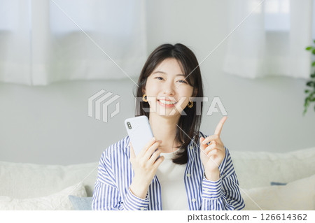 A woman watching a smartphone A woman watching a smartphone 126614362