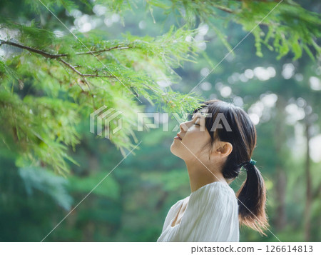 A woman taking photos in a green forest park 126614813