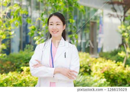 一位身穿白大褂的女士在戶外微笑 一位身穿白大褂的女士在戶外微笑 126615029