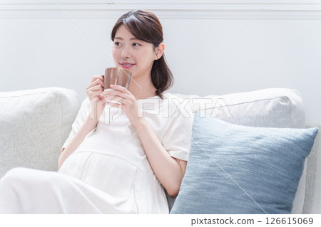 Pregnant woman drinking from a mug Pregnant woman drinking from a mug 126615069