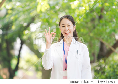 一位身穿白大褂的女士在戶外微笑 一位身穿白大褂的女士在戶外微笑 126615204