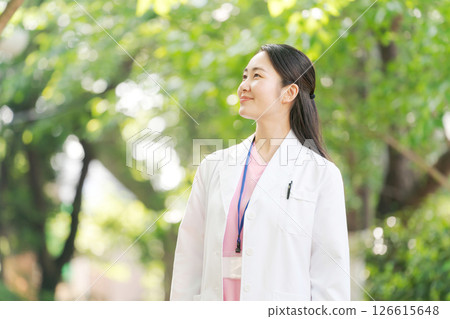 一位身穿白大褂的女士在戶外微笑 126615648