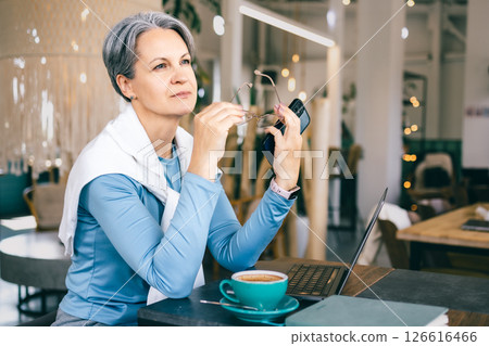 Senior woman with gray hair taking a mindful break from work, coping with fatigue Senior woman with gray hair taking a mindful break from work, coping with fatigue 126616466