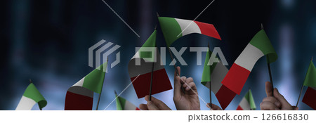 Italy flags in their hands on a blurred urban background Italy flags in their hands on a blurred urban background 126616830